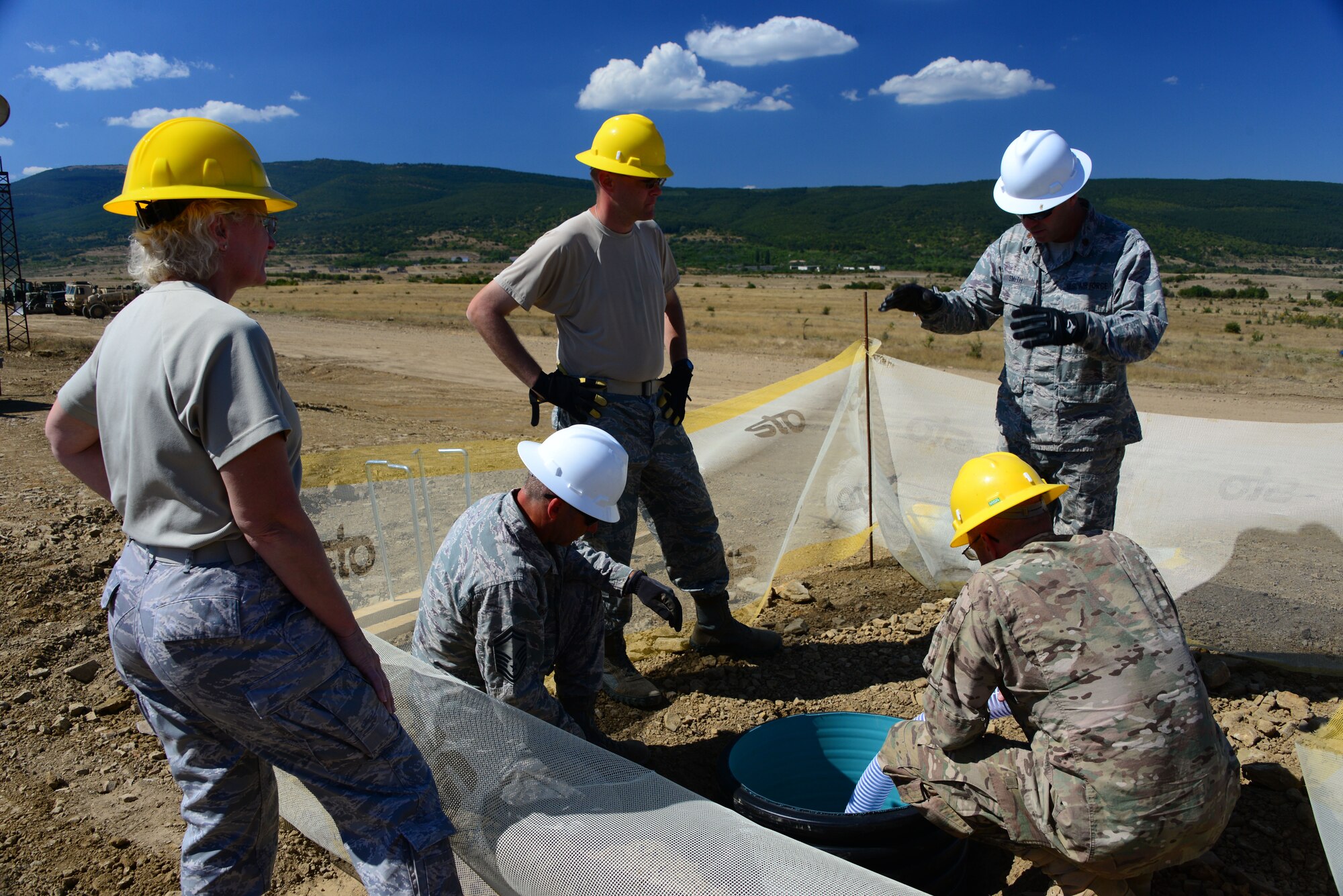Airmen from the 118th Mission Support Group, Tennessee Air National Guard, and the 194th Engineer Brigade, Tennessee Army National Guard, install lighting foundations at the Ammo Holding Area, better known as the AHA, Aug. 16, 2016, at Novo Selo Training Area, Bulgaria.  Tennessee National Guard Soldiers and Airmen were on rotations to complete thier portions of projects as part of Operation Resolute Castle 16, an ongoing operation of military construction to build up Eastern European base infrastructure and help strengthen ties between Tennessee's state partnership with Bulgaria. (U.S. Air National Guard photo by Master Sgt. Kendra M. Owenby, 134 ARW Public Affairs)