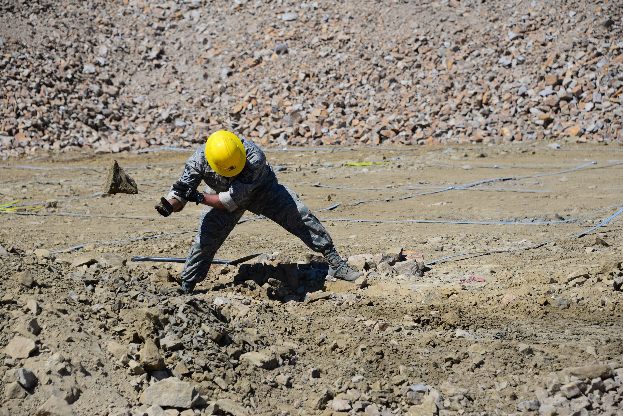 1st Sgt. Michael Parson, 118th Mission Support Group, Tennessee Air National Guard, clears rocks for a foundation for the Ammo Holding Area, better known as the AHA, Aug. 16, 2016, at Novo Selo Training Area, Bulgaria.  Tennessee National Guard Soldiers and Airmen were on rotations to complete thier portions of projects as part of Operation Resolute Castle 16, an ongoing operation of military construction to build up Eastern European base infrastructure and help strengthen ties between Tennessee's state partnership with Bulgaria. (U.S. Air National Guard photo by Master Sgt. Kendra M. Owenby, 134 ARW Public Affairs)