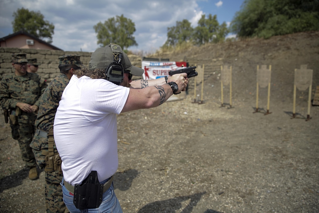Instructor Zero, a chief instructor with Spartan 360 Tactical Defense fires his handgun at a target with a Marine from Special Purpose Marine Air-Ground Task Force Crisis Response-Africa during a live-fire range near Naval Air Station Sigonella, Italy, Sept. 10, 2016.  Marines with SPMAGTF-CR-AF took an advanced shooting course with Instructor Zero, who went over fundamentals and tactics of firing a handgun.  (U.S. Marine Corps photo by Cpl. Alexander Mitchell/released)