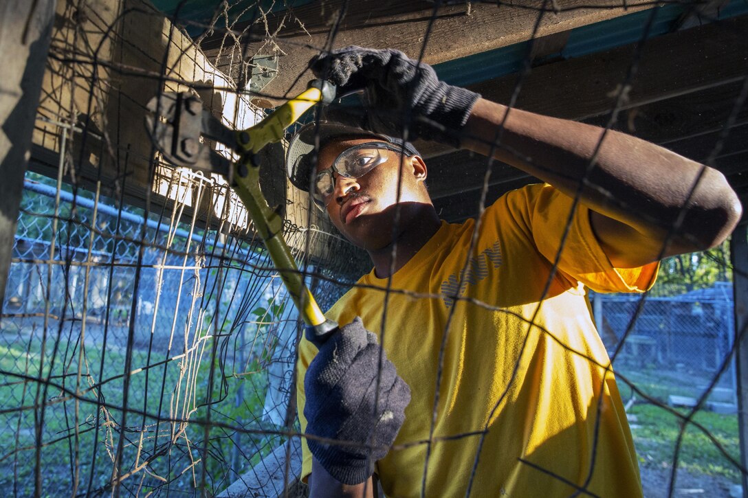 A Navy airman cuts wires off an old shed during a community relations event at the Animal Aid Society in Hampton, Va., Sept. 13, 2016. The sailor is assigned to the USS Abraham Lincoln, which is undergoing a refueling and overhaul at Newport News Shipbuilding. Navy photo by Seaman Ashley Raine Northen