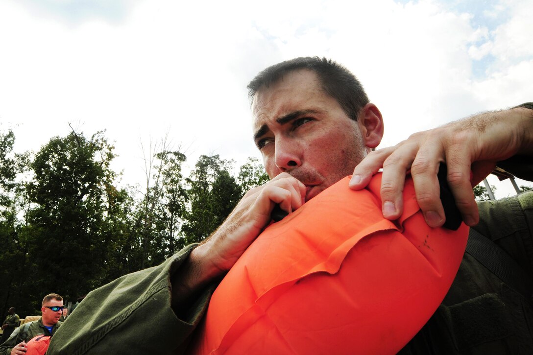 Air Force Capt. Jonathan Hallman manually inflates a life preserver during a water survival refresher course at Camp John J. Barnhardt, New London, N.C., Sept. 10, 2016. Hallman is a C-130 Hercules pilot assigned to the 156th Airlift Squadron. Air National Guard photo by Staff Sgt. Julianne M. Showalter