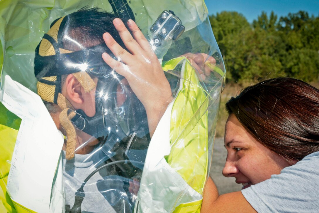 Air National Guard Senior Airman Nicolett Bagonis, right, adjusts Staff Sgt. Melissa Isidro's mask during Exercise Clean House at Joint Base McGuire-Dix-Lakehurst, N.J., Sept. 14, 2016. Air National Guard photo by Tech. Sgt. Matt Hecht