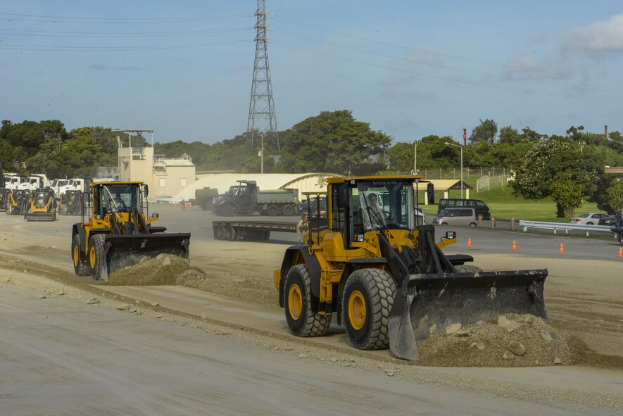 Airmen operate heavy machinery to clear debris away from a simulated damaged area created during rapid airfield damage repair training Sept. 15, 2016, at Kadena Air Base, Japan. Civil engineer squadrons from Kadena, Yakota and Misawa Air Bases teamed up with the Air Force Civil Engineer Center from Tyndall Air Force Base, Fla., to conduct training for the new rapid airfield damage repair (RADR) technique Sept. 12-15. (U.S. Air Force photo/Senior Airman Stephen G. Eigel)