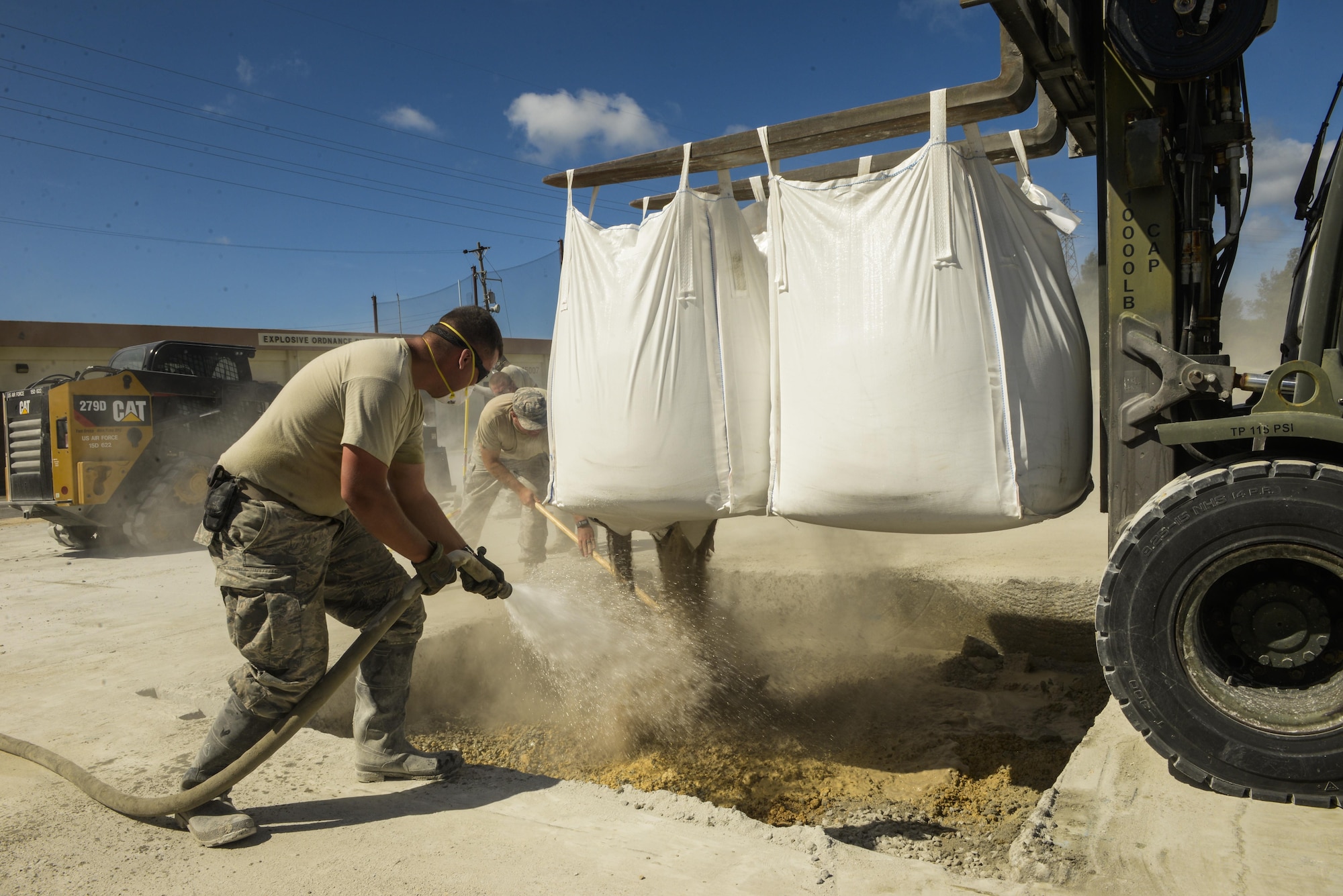 A joint team of U.S. Air Force Airmen from the Kadena, Yakota and Misawa civil engineer squadrons mix water and a low-strength concrete together during airfield damage repair training exercise Sept, 15, 2016, at Kadena Air Base, Japan. During the RADR Airmen clear the debris from the surface of the flightline using heavy equipment such as bulldozers and then cut a square around the damaged areas or craters with a specialized saw. (U.S. Air Force photo by Senior Airman Stephen G. Eigel)