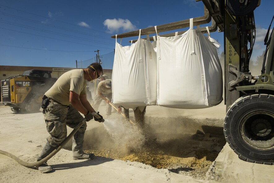 A joint team of Airmen from civil engineer squadrons at Kadena, Yakota and Misawa Air Bases mix water and a low-strength concrete during an airfield damage repair training exercise Sept. 15, 2016, at Kadena AB, Japan. During the exercise Airmen cleared debris from the surface of the flightline using heavy equipment such as bulldozers then cut a square around the damaged areas or craters with a specialized saw. (U.S. Air Force photo/Senior Airman Stephen G. Eigel)