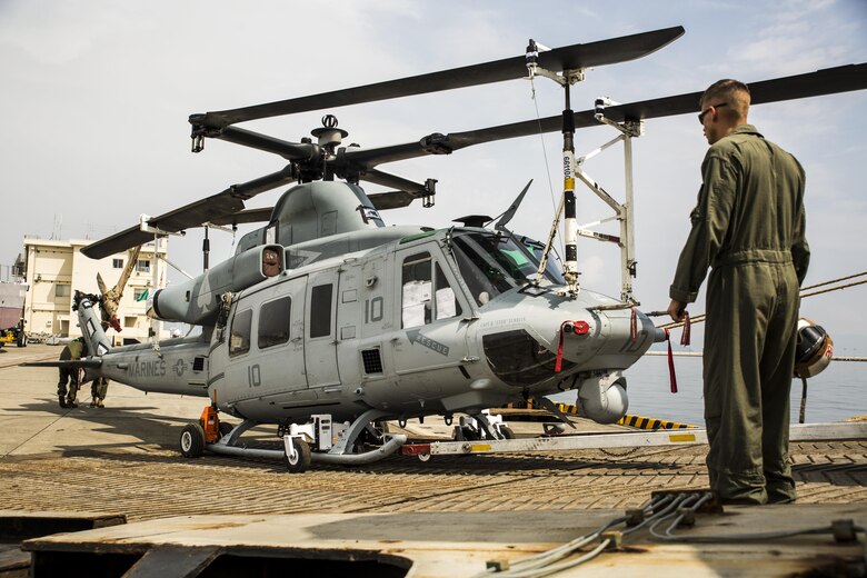 U.S. Marines with Marine Light Attack Helicopter Squadron (HMLA) 469, unload a UH-1Y Venom at Marine Corps Air Station Iwakuni, Japan, Sept. 16, 2016. Three UH-1Y Venoms, two MV-22C Ospreys and one CH-53E Super Stallion, and are scheduled to fly to their destination in Okinawa after concluding preparations at MCAS Iwakuni. The Green Cove, a vehicle carrier, transported the aircraft approximately 6,000 miles from Naval Air Station North Island, San Diego, Calif. Delivering aircraft by boat is more cost effective than flying from the U.S. to Japan, and MCAS Iwakuni has both airport and seaport capabilities, which no other Marine Corps installation has. (U.S. Marine Corps photo by Lance Cpl. Aaron Henson)