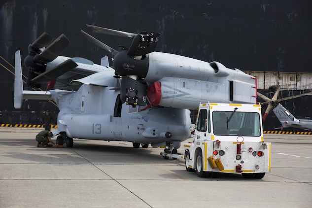 U.S. Marines with Marine Medium Tiltrotor Squadron (VMM) 265, unload an MV-22C Osprey at Marine Corps Air Station Iwakuni, Japan, Sept. 16, 2016. Three UH-1Y Venoms, two MV-22C Ospreys and one CH-53E Super Stallion, and are scheduled to fly to their destination in Okinawa after concluding preparations at MCAS Iwakuni. The Green Cove, a vehicle carrier, transported the aircraft approximately 6,000 miles from Naval Air Station North Island, San Diego, Calif. Delivering aircraft by boat is more cost effective than flying from the U.S. to Japan, and MCAS Iwakuni has both airport and seaport capabilities, which no other Marine Corps installation has. (U.S. Marine Corps photo by Lance Cpl. Aaron Henson)