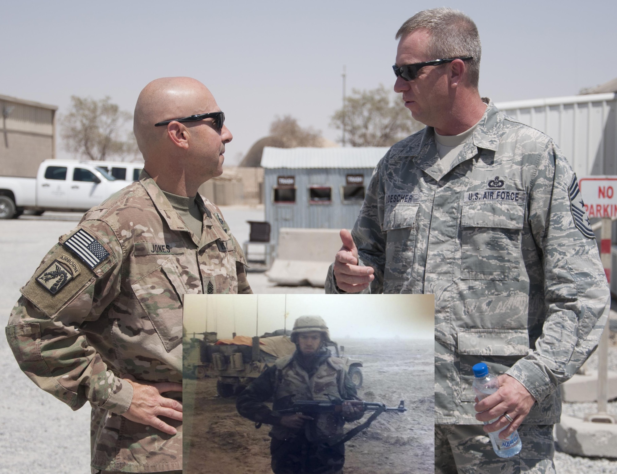 NOW AND THEN – Command Chief Master Sgt. Scott Loescher talks with Combined Joint Task Force – Operation Inherent Resolve Command Sgt. Maj. Benjamin Jones, Sept. 9, 2016 at the Rock (US Air Force photo/Master Sgt. Anika Jones). The command chief serves at the very same location in Southwest Asia that he served a quarter-century earlier, as seen in the inset photo, when he was part of Operation Desert Storm. Then, Airman 1st Class Loescher is pictured after the cease fire was called, early March 1991. (Courtesy photo) 