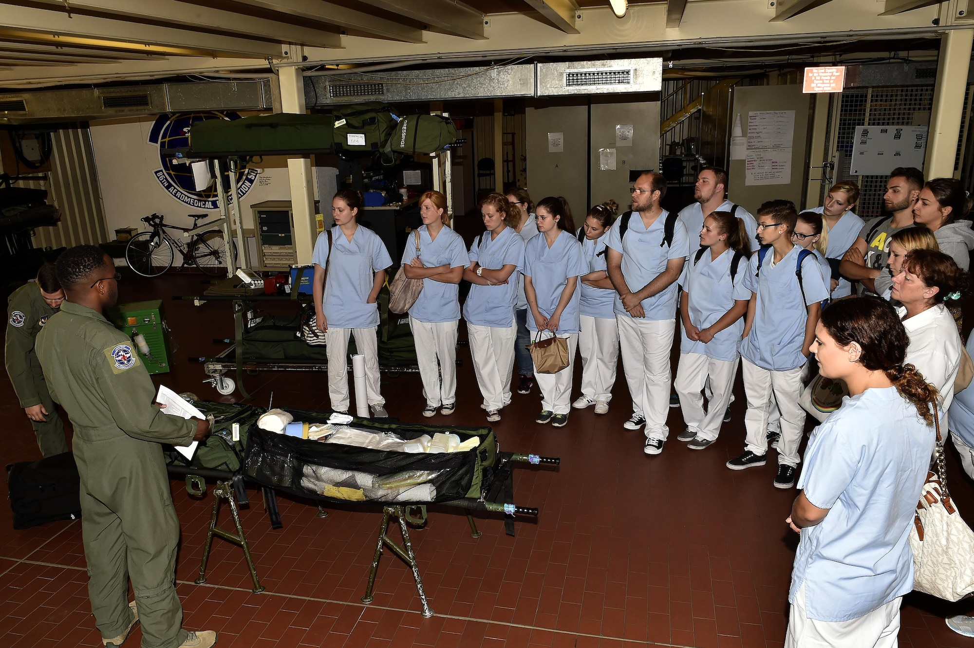 Nursing students from Caritas SchulZentrum St. Hildegard, Saarbrücken, Germany, listen to a flight medic from the 86th Aeromedical Evacuation Squadron during a tour of the 86th AES facilities at Ramstein Air Base, Germany, Sept. 13, 2016. The students received an introduction to the 86th AES mission from Airmen assigned to the squadron. (U.S. Air Force photo by Senior Airman Jonathan Bass)
