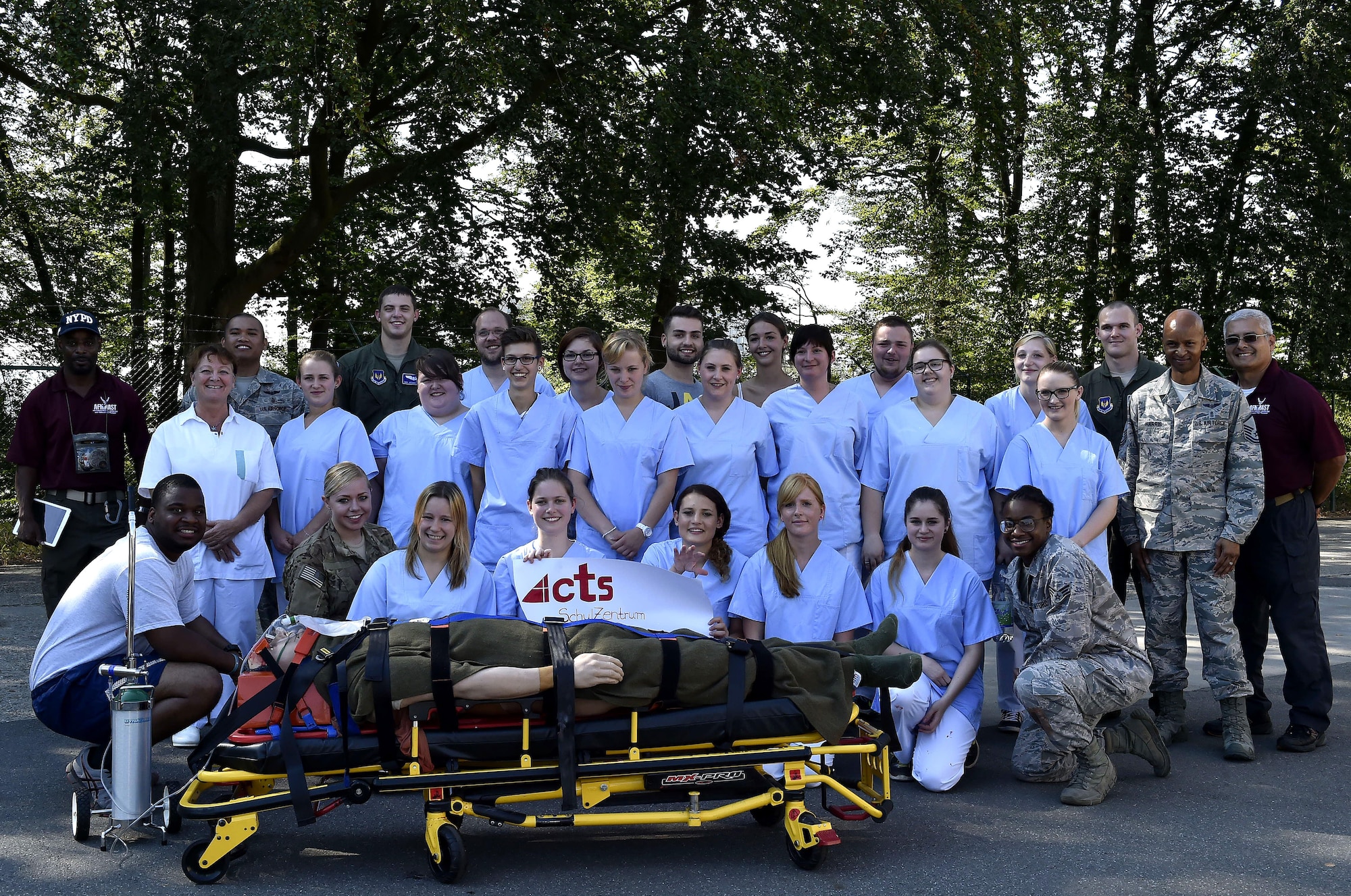 Nursing students from Caritas SchulZentrum St. Hildegard, Saarbrücken, Germany, along with medics from the 86th Aeromedical Evacuation Squadron, and 86th Medical Group simulation team members pose for a photo after a simulated mass casualty training scenario at Ramstein Air Base, Germany, Sept. 13, 2016. The visit allowed the students to learn opportunities where Air Force nurses can incorporate their skillsets and training in an environment outside of the traditional clinical setting. (U.S. Air Force photo by Senior Airman Jonathan Bass)