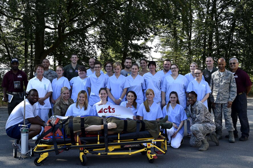 Nursing students from Caritas SchulZentrum St. Hildegard, Saarbrücken, Germany, along with medics from the 86th Aeromedical Evacuation Squadron, and 86th Medical Group simulation team members pose for a photo after a simulated mass casualty training scenario at Ramstein Air Base, Germany, Sept. 13, 2016. The visit allowed the students to learn opportunities where Air Force nurses can incorporate their skillsets and training in an environment outside of the traditional clinical setting. (U.S. Air Force photo by Senior Airman Jonathan Bass)