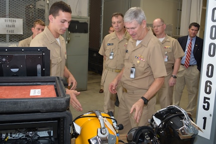 Navy Diver 3rd Class Mitchell Lafave explains the different gear used by the Dive Locker with Naval Sea Systems Command Commander Vice. Adm. Tom Moore as Rear Adm. James Downey, Commander Regional Maintenance Center observes at Southeast Regional Maintenance Center (SERMC) at Jacksonville, Fla. Sept. 1st. Photo by Scott Curtis.