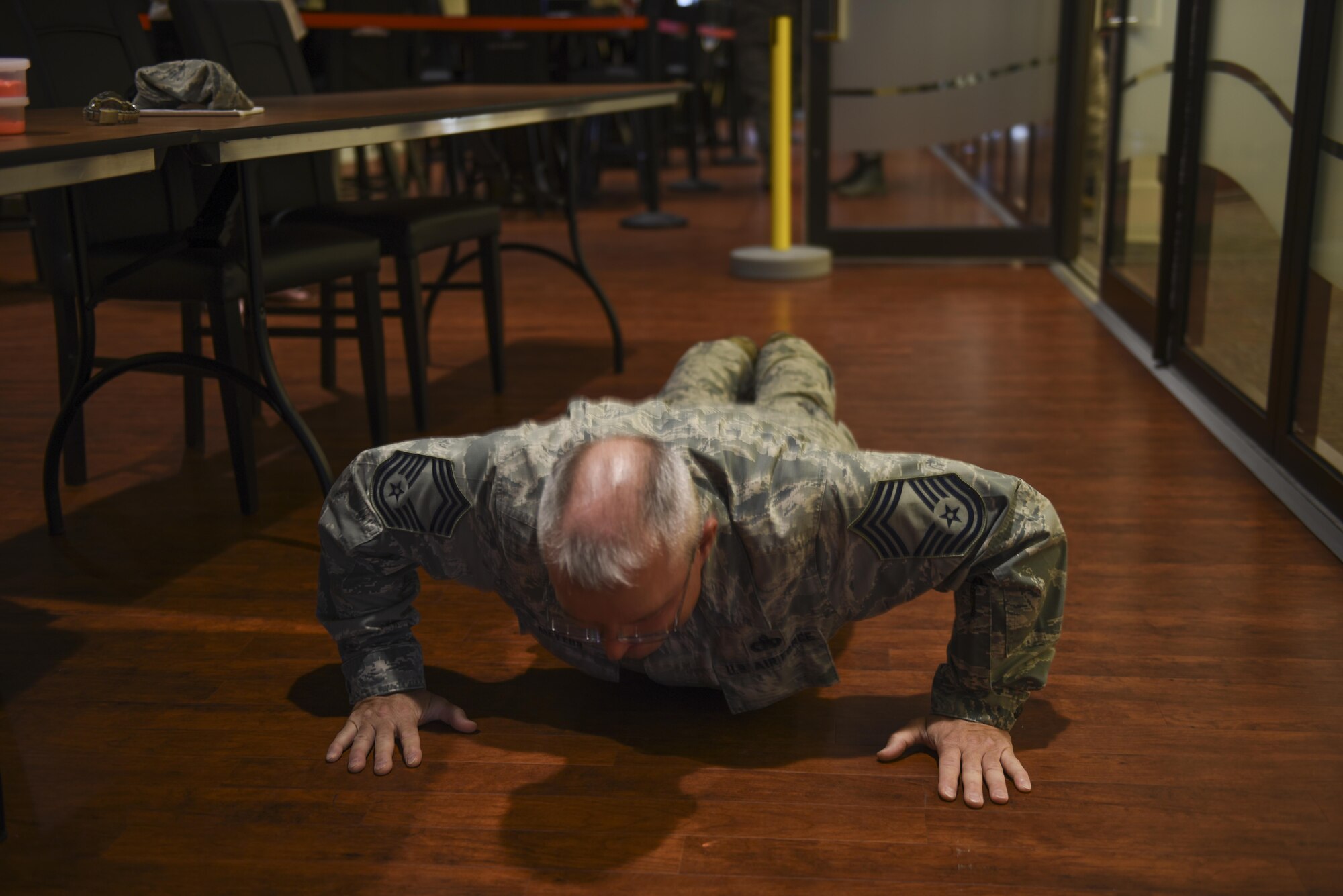 Chief Master Sgt. Martin Meyers, operations superintendent with the 32nd Aerial Port Squadron, performs a pushup at the Community Access Center at the Pittsburgh International Airport Air Reserve Station, Pa, September 10, 2016. Meyers was participating in a pushup contest to raise awareness for mental and physical health. (U.S. Air Force photo by Staff Sgt. Allissa Landgraff)