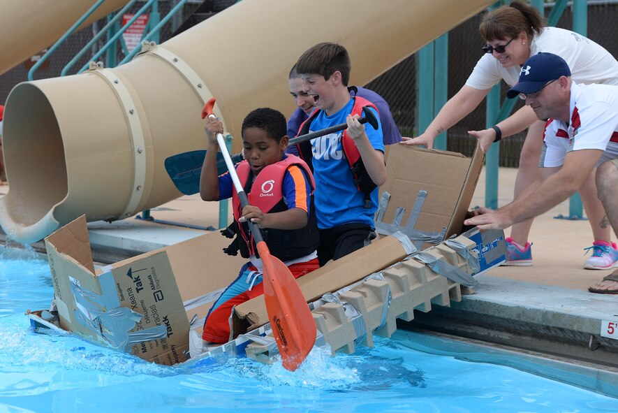 Giovoni Fleurimond, 10 (left), and Cameron Mann, 12, charge into the water during the 2016 Cardboard Boat Race on Laughlin Air Force Base, Texas, Sept. 10, 2016. Using a homemade and handcrafted vessel, Fleurimond and Mann sailed the entire length of the pool here. (U.S. Air Force photo Airman 1st Class Benjamin N. Valmoja)