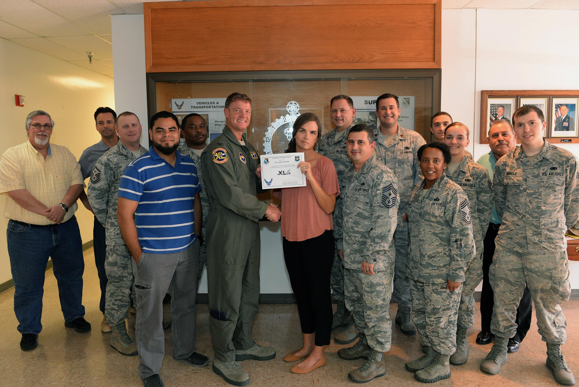 Ashlyn Marble (front), 47th Logistics Readiness Flight secretary office automation, accepts the “XLer of the Week” award from Col. Thomas Shank (front left), 47th Flying Training Wing commander, and Chief Master Sgt. George Richey (front right), 47th FTW command chief on Laughlin Air Force Base, Texas, Sept. 8, 2016. The XLer is a weekly award chosen by wing leadership and is presented to those who consistently make outstanding contributions to their unit and Laughlin. (U.S. Air Force photo/Airman 1st Class Benjamin N. Valmoja)