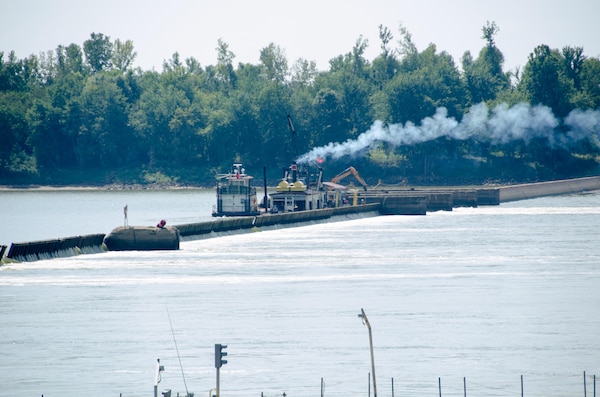 The steam work boat lifts the smaller wickets near the bear trap section of the dam to retain pool depth for navigation at Locks and Dam 52 on the Ohio River at Brookport, Illinois.