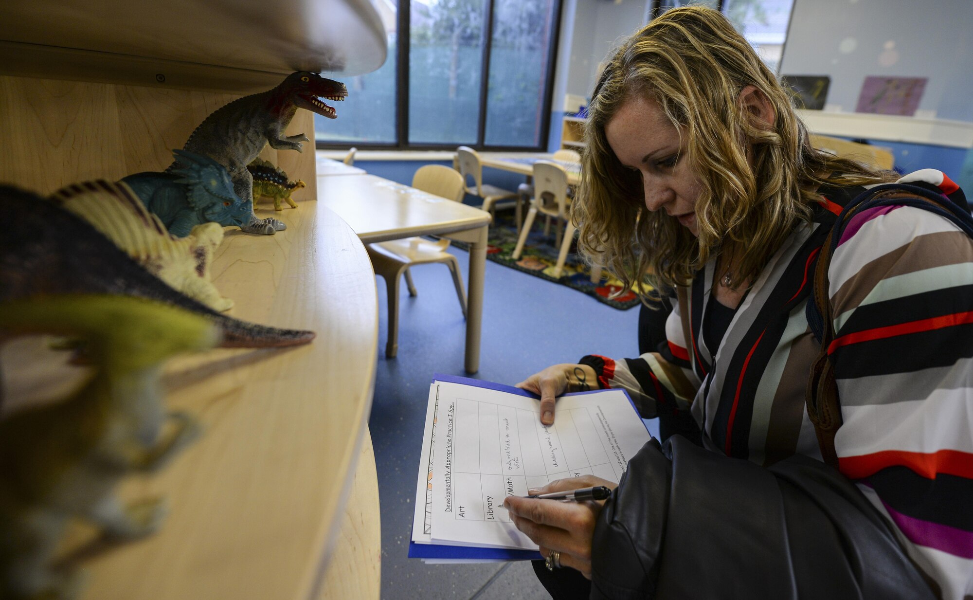 Petra Williamson, Child Development Center lead program technician, assess objects in a classroom during the 2016 Child and Youth Programs Training Conference for the U.K. Sept. 10, 2016, on RAF Mildenhall, England. Childcare providers were instructed to inspect a classroom to find discrepancies such as non-age-appropriate toys, mislabeled objects, improperly displayed items and product endorsement. (U.S. Air Force photo by Staff Sgt. Micaiah Anthony)