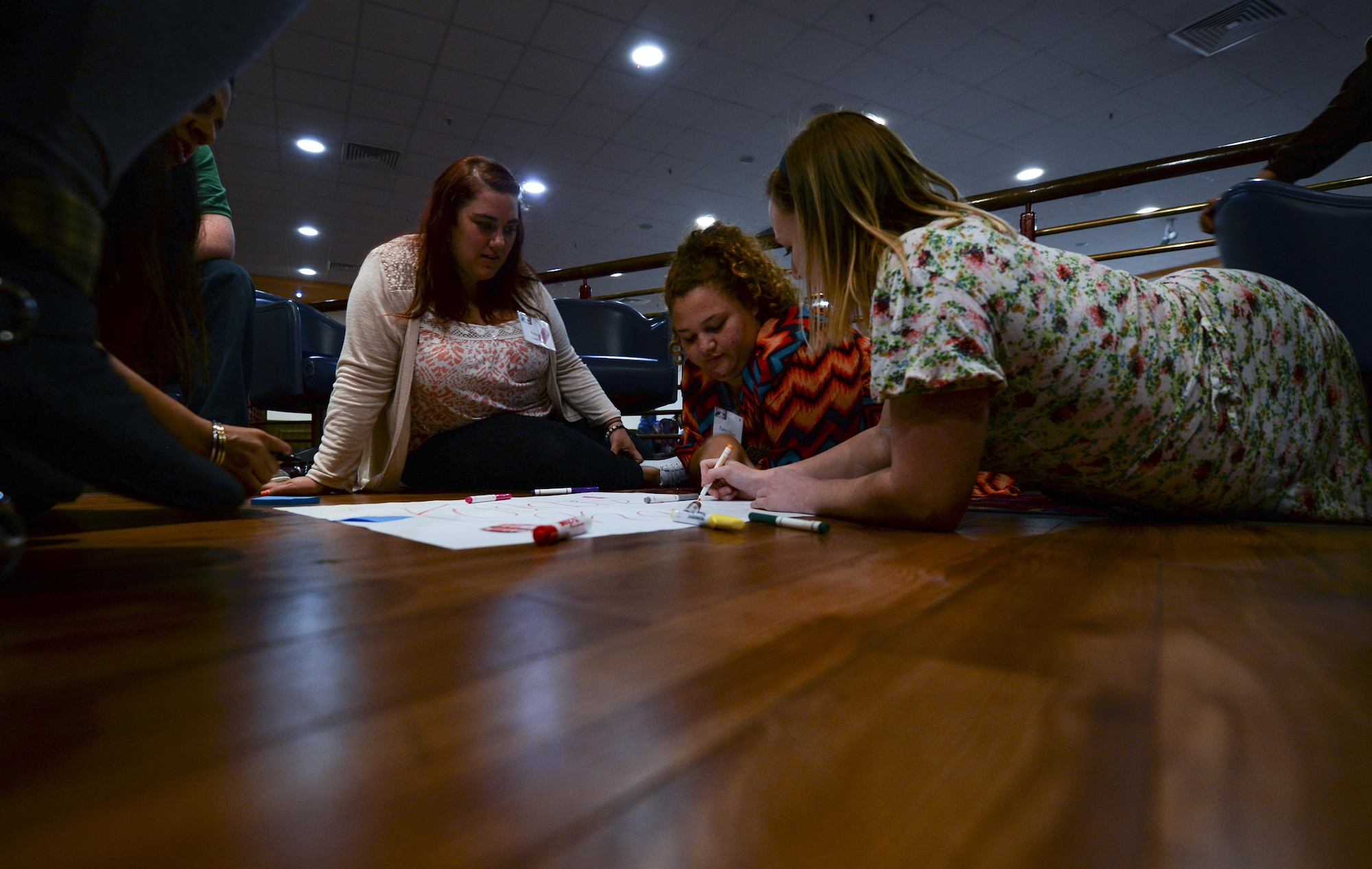 Participants in the 2016 Child and Youth Programs Training Conference for the U.K. work on a poster during a Four Lenses session Sept. 10, 2016, on RAF Mildenhall, England. Four Lenses is made up of four color-coded temperaments denoting how someone views and reacts to the world around them. During the training childcare providers learned how to work more effectively with people with different lens colors. (U.S. Air Force photo by Staff Sgt. Micaiah Anthony)