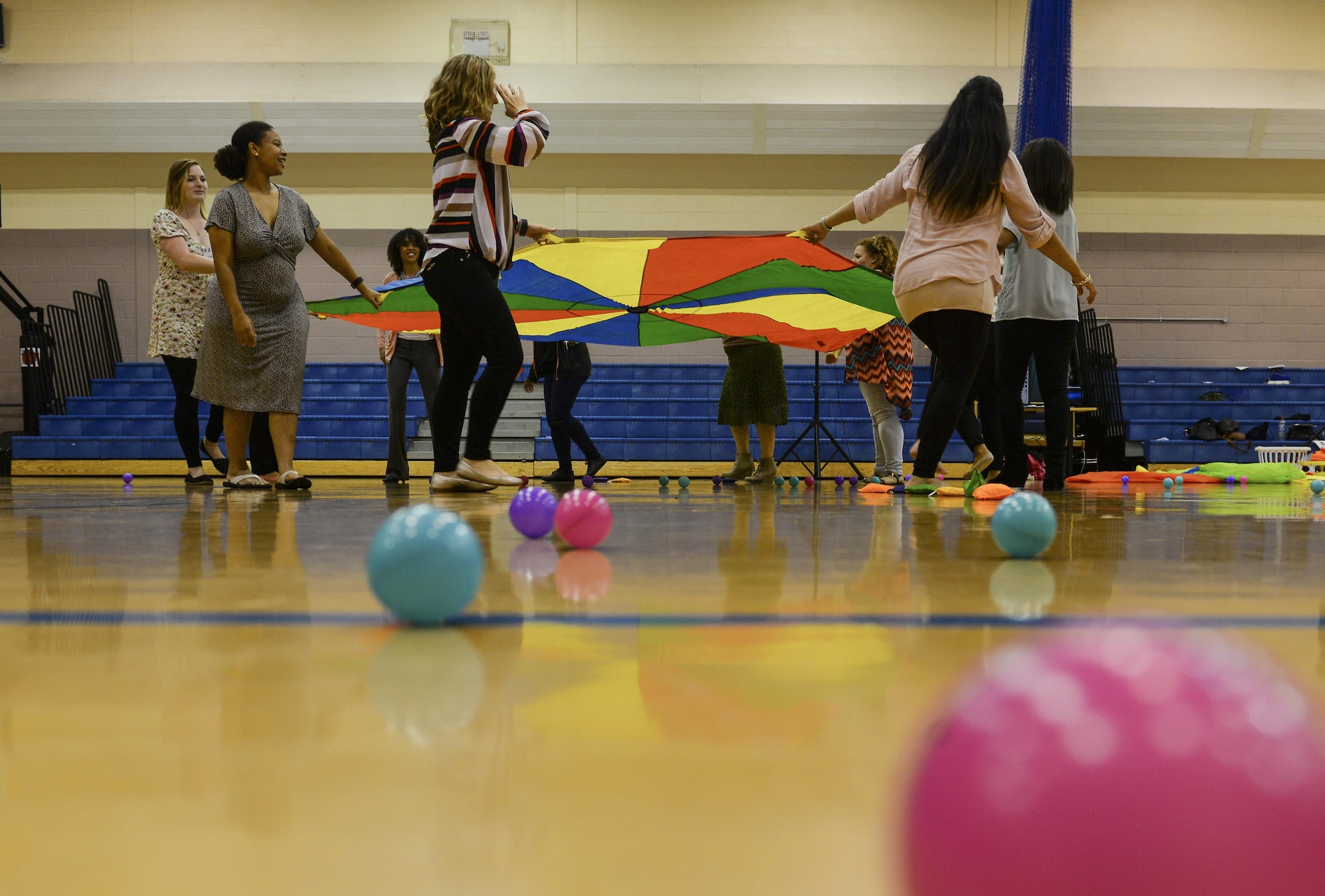 Participants in the 2016 Child and Youth Programs Training Conference for the U.K. participate in the Parachute Play class Sept. 10, 2016, on RAF Mildenhall, England. The class focused on how to entertain children of all ages with parachute play which incorporated several different objects, songs, stories and games to be used in the activity. (U.S. Air Force photo by Staff Sgt. Micaiah Anthony)