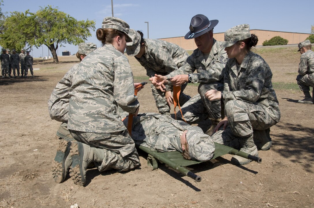 3rd WOT Trainees securing simulated wounded patient to litter during self-aid and buddy care class.