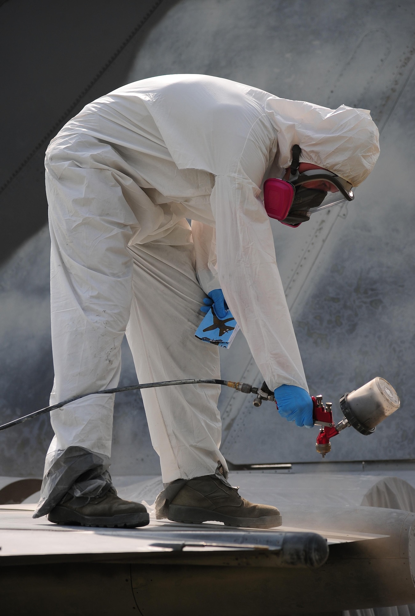 A low observable technician from the 509th Maintenance Squadron, spray a coating of paint onto an FB-111A General Dynamics Aardvark static display at Whiteman Air Force Base, Mo., Sept. 13, 2016. During the restoration process, the aircraft was sanded, primed, repainted and received corrosion maintenance. (U.S. Air Force photo by Senior Airman Joel Pfiester)