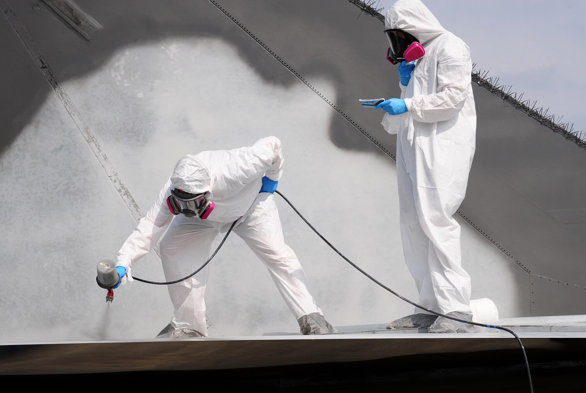 Low observable technicians from the 509th Maintenance Squadron, spray a coating of paint onto an FB-111A General Dynamics Aardvark static display at Whiteman Air Force Base, Mo., Sept. 13, 2016. During the restoration process, the aircraft was sanded, primed, repainted and received corrosion maintenance. (U.S. Air Force photo by Senior Airman Joel Pfiester)
