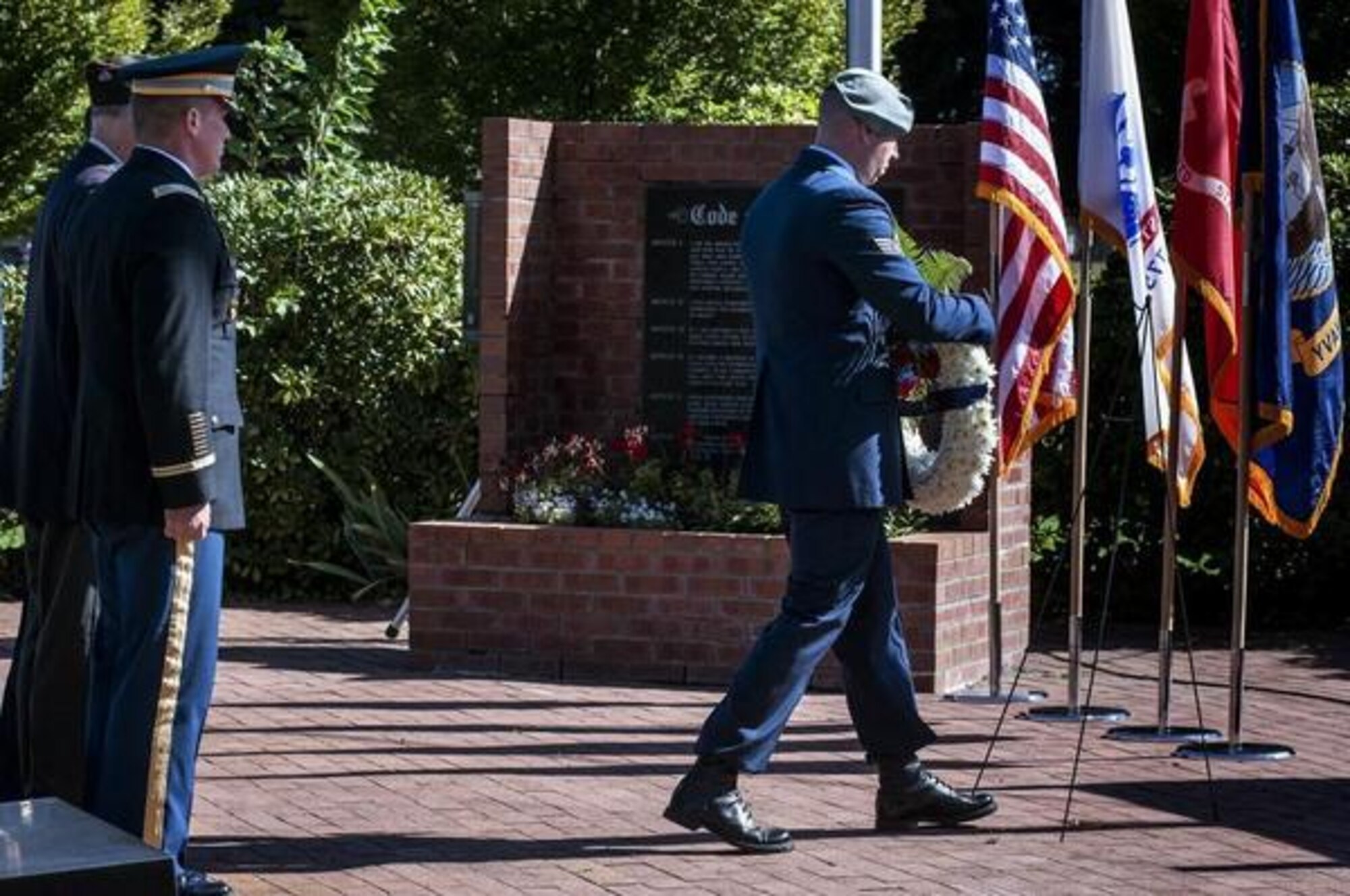 Staff Sgt. David Bowden, right, places a wreath during a POW/MIA Week observance at Memorial Grove Garden on McChord Field Sept. 12, 2016, at Joint Base Lewis-McChord, Wash.(Courtesy photo)   