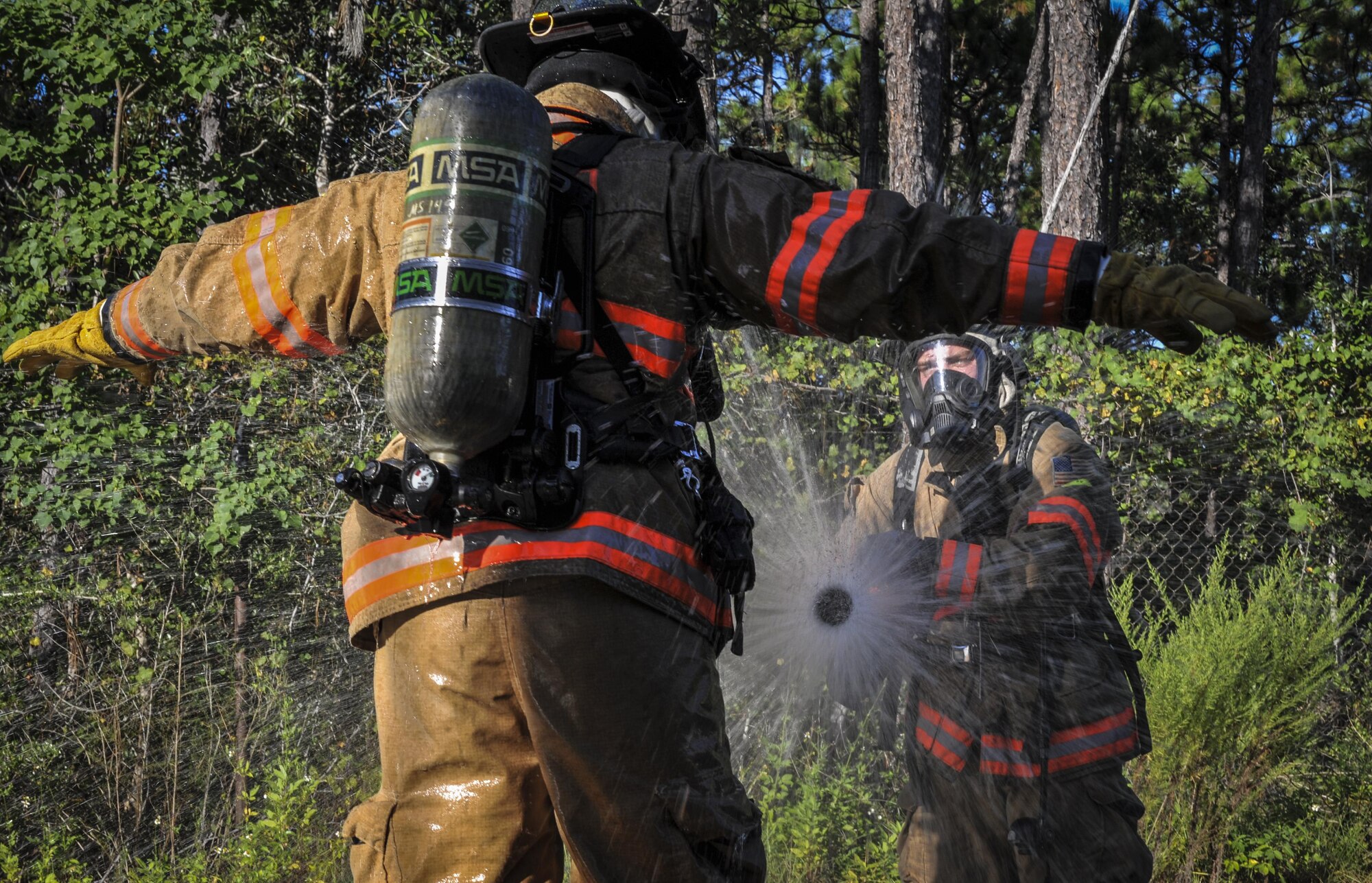 Airman 1st Class Derrick Stanley, a firefighter with the 1st Special Operations Civil Engineering Squadron, hoses down Senior Airman Ryan Houghtaling, a firefighter with the 1 SOCES, during an exercise at Hurlburt Field, Fla., Sept. 15, 2016. The 1st Special Operations Wing conducted a three-day exercise to ensure personnel are update to date on emergency response procedures. (U.S Air Force photo by Airman 1st Class Joseph Pick)
