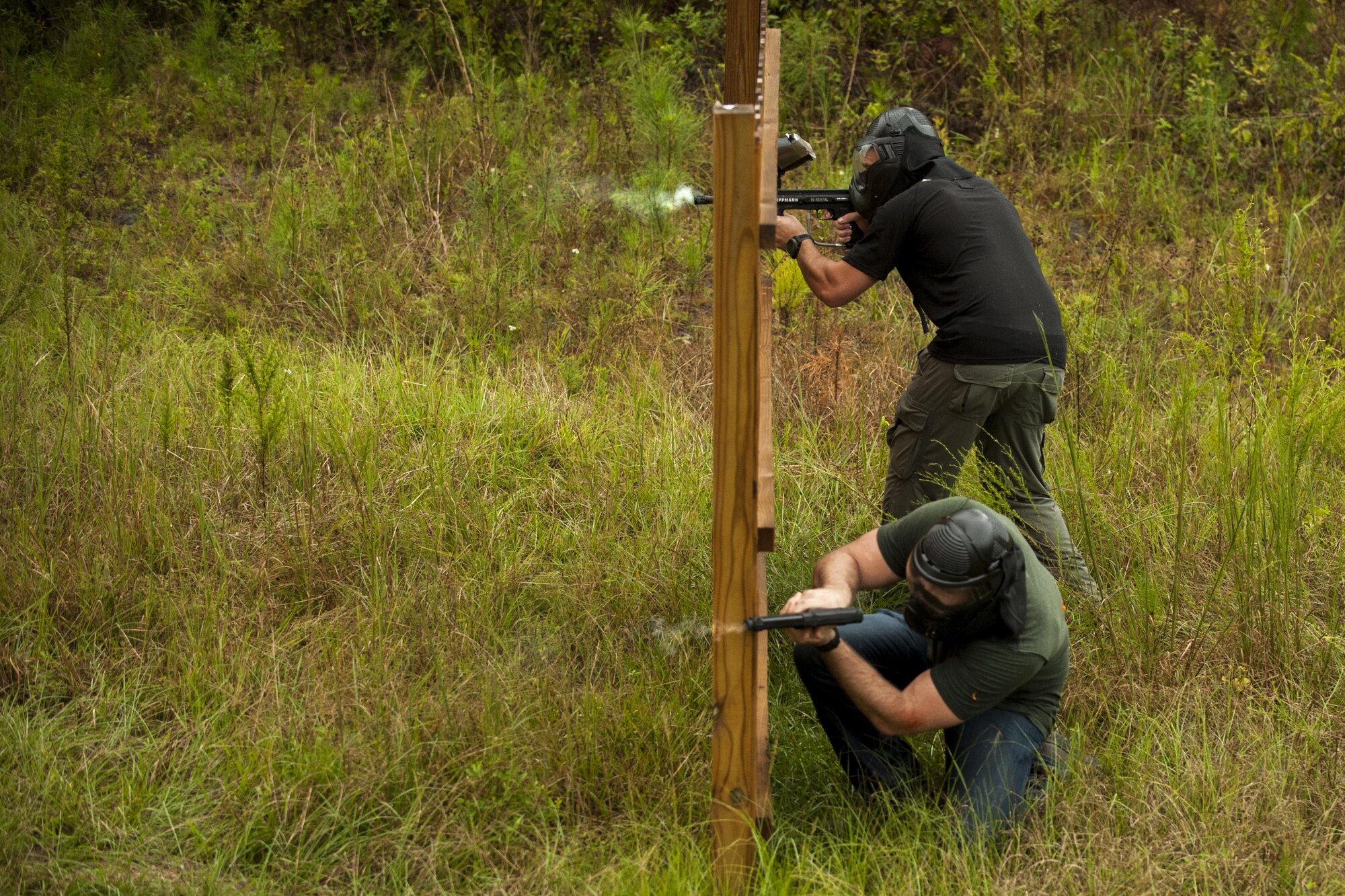 U.S. Air Force Staff Sgt. Phillip Palmer, 71st Rescue Squadron HC-130J Combat King II loadmaster, top, and Capt. Peter Arnold, 71st Rescue Squadron HC-130J pilot, simultaneously fire paintball rounds during combat survival training, Sept. 13, 2016, at Moody Air Force Base, Ga. The CST was conducted at a newly built course, which simulates a training environment for aircrews to prevent the chances of getting captured by enemy forces.  (U.S. Air Force photo by Airman 1st Class Daniel Snider)