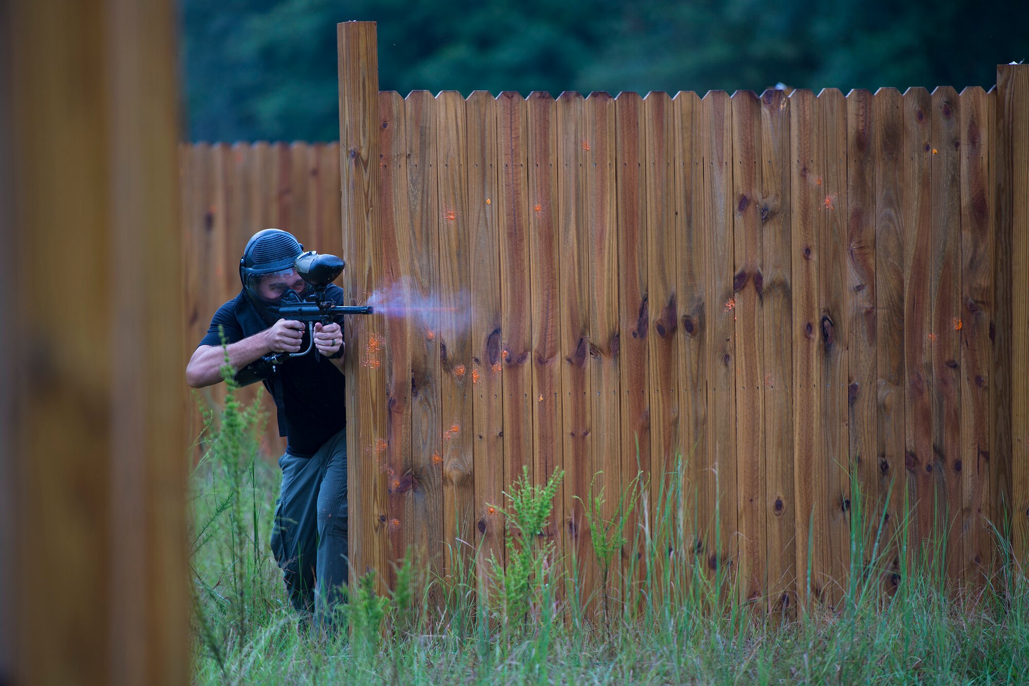 U.S. Air Force Capt. Peter Arnold, 71st Rescue Squadron HC-130 J Combat King II pilot, fires a paintball towards the opposition, during combat survival training, Sept. 13, 2016, at Moody Air Force Base, Ga. Airmen participated in multiple rounds of CST against an array of teams practicing different survival tactics to efficiently evade, resist and escape enemy threats.  (U.S. Air Force photo by Airman 1st Class Greg Nash)