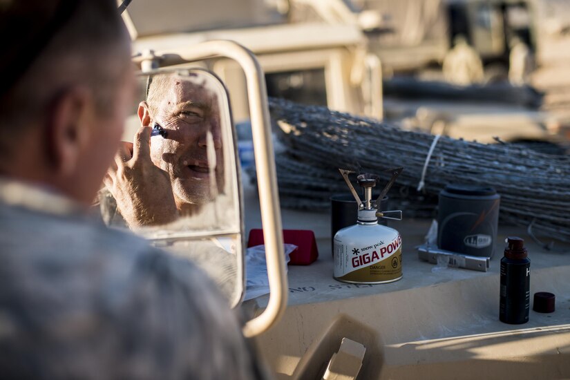 Sgt. 1st Class Patrick Shipp, a civil affairs Soldier from Virginia Beach, Va., assigned to the 437th Civil Affairs Battalion, shaves using a humvee mirror at dawn at National Training Center Fort Irwin, Calif., Sept. 5, 2016. The 437th Civil Affairs Bn. keeps troops trained and proficient in order to support the s 352nd Civil Affairs Command’s mission to support the Central Command area of operations. (U.S. Army photo by Master Sgt. Mark Burrell, 352nd CACOM)