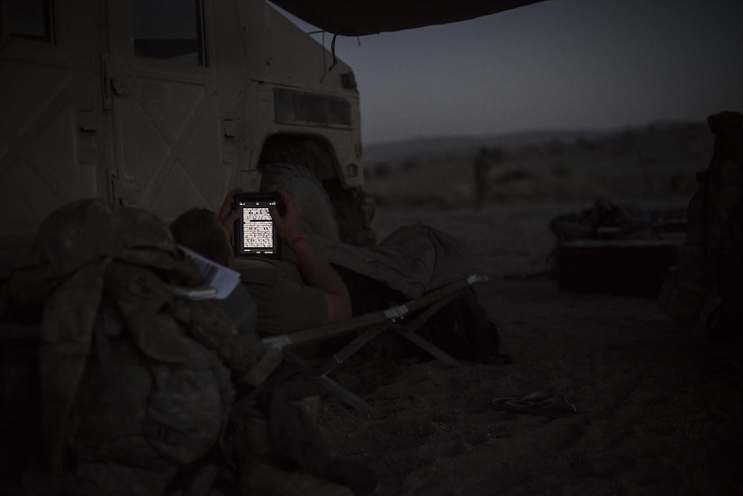 Civil affairs 1st Lt. Brandon Wilson from Tunkhannock, Penn., assigned to the 437th Civil Affairs Battalion reads an electronic book at dusk at National Training Center Fort Irwin, Calif., Sept. 5, 2016. The 437th Civil Affairs Bn. keeps troops trained and proficient in order to support the s 352nd Civil Affairs Command’s mission to support the Central Command area of operations. (U.S. Army photo by Master Sgt. Mark Burrell, 352nd CACOM)