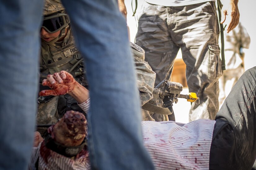 Spc. Madelyn Riccio, a civil affairs Soldier from Virginia Beach, Va., assigned to the 437th Civil Affairs Battalion, puts a tourniquet on a role player simulating an injury during training at National Training Center Fort Irwin, Calif., Sept. 7, 2016. The 437th Civil Affairs Bn. keeps troops trained and proficient in order to support the s 352nd Civil Affairs Command’s mission to support the Central Command area of operations. (U.S. Army photo by Master Sgt. Mark Burrell, 352nd CACOM)