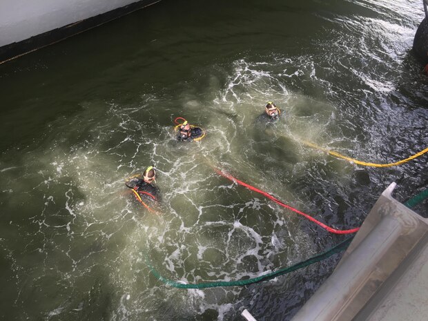 Navy Diver 1st Class Justin Cavitt (L), Navy Diver 2nd Class Christopher Throne and Lieut. Benjamin Carroll prepare to leave the surface for a diver on USS New York (LPD-21) Sept. 13th at Southeast Regional Maintenance Center (SERMC) in Mayport, Fla.