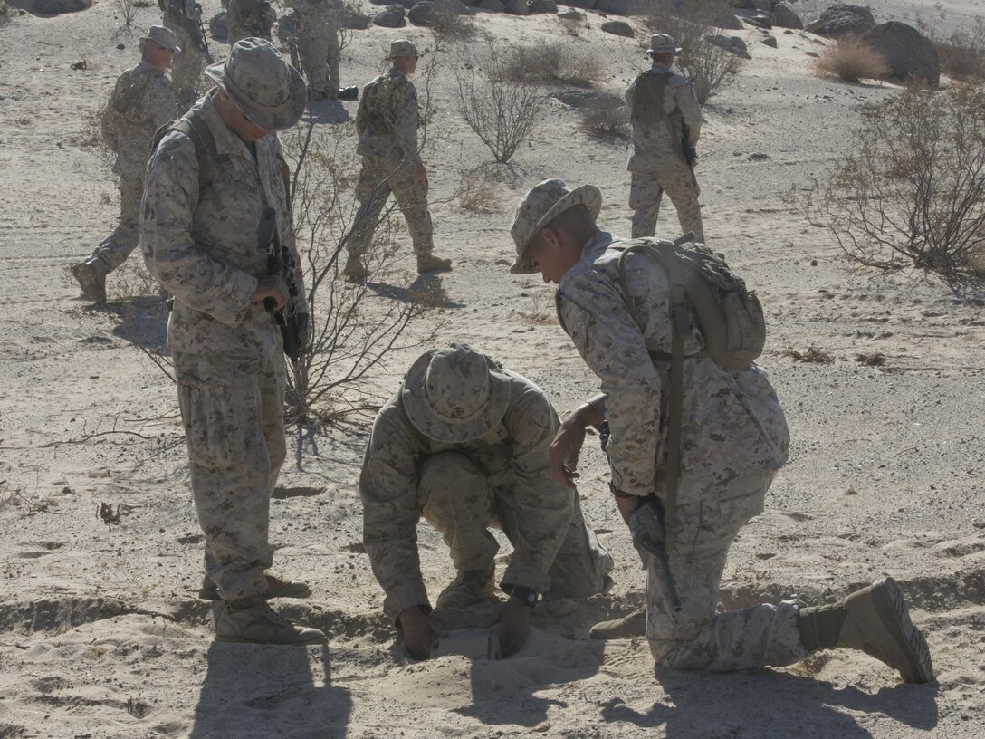 Marines with Company A, 3rd Light Armored Reconnaissance Battalion, practice planting simulated Improvised Explosive Devices at Range 100 aboard Marine Corps Air Ground Combat Center, Twentynine Palms, Calif., Sept. 8, 2016. During the training, the Marines practiced a variety of exercises to include patrolling, land navigation as well as planting and locating improvised explosive devices. (Official Marine Corps photo by Cpl. Thomas Mudd/Released)