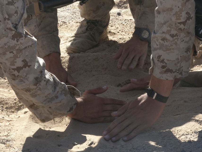 Marines with Company A, 3rd Light Armored Reconnaissance Battalion, bury simulated Improvised Explosive Devices at Range 100 aboard Marine Corps Air Ground Combat Center, Twentynine Palms, Calif., Sept. 8, 2016. The training prepared the company to be the opposing force for 3rd LAR, Company C. (Official Marine Corps photo by Cpl. Thomas Mudd/Released)