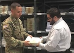 Flight Information Publications Program Manager Julio Bultron, right, hands off an aeronautical map that was printed on demand to Army Captain Joel Castro from the 3-82 General Support Aviation Battalion, 82nd Combat Aviation Brigade, 82nd Airborne Division, Sept. 14, 2016.  Bultron is helping to staff the new Geospatial Intelligence - Forward Presence Team on Fort Bragg, North Carolina.  Defense Logistics Agency Aviation Customer Operations Directorate's Mapping Division will host a facility open house Sept. 28 from 10 a.m. to 2 p.m. at the U.S. Army Forces Command Intelligence Readiness and Operations Center on Fort Bragg, North Carolina.  
