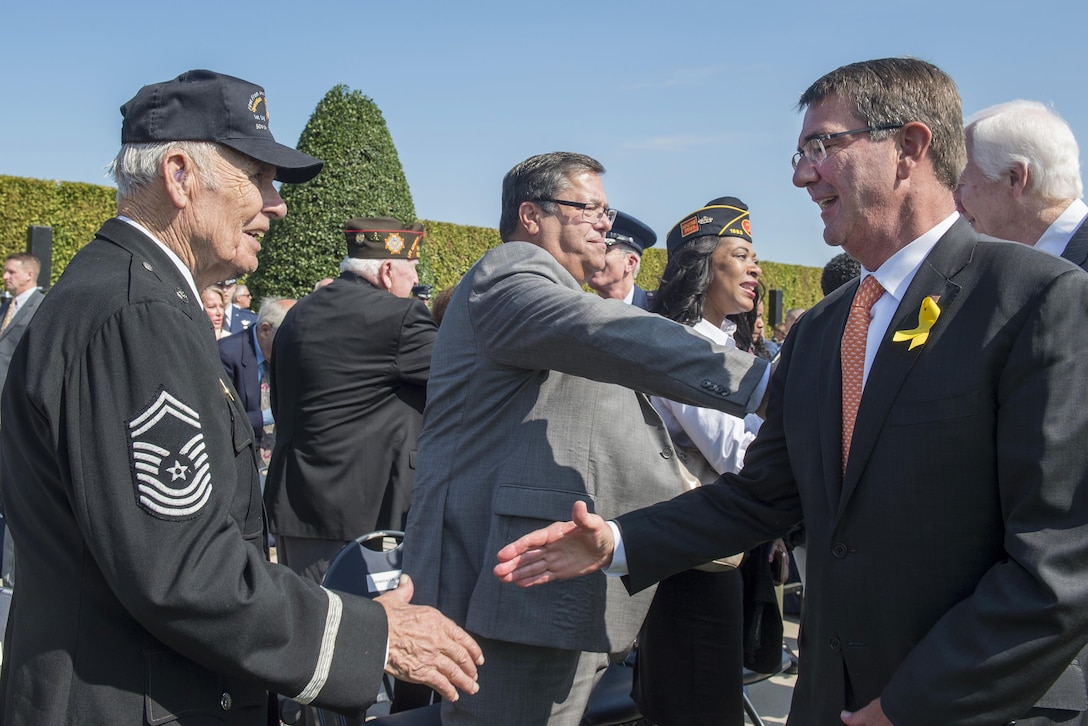 Defense Secretary Ash Carter, right, shakes hands with retired Air Force Chief Master Sgt. William Tippins during a POW/MIA ceremony at the Pentagon, Sept. 16, 2016. Tippins was a prisoner of war for 18 months during World War II. National POW/MIA Recognition Day is observed on the third Friday in September and honors those who were prisoners of war and those who are still missing in action. DoD photo by Air Force Tech. Sgt. Brigitte N. Brantley