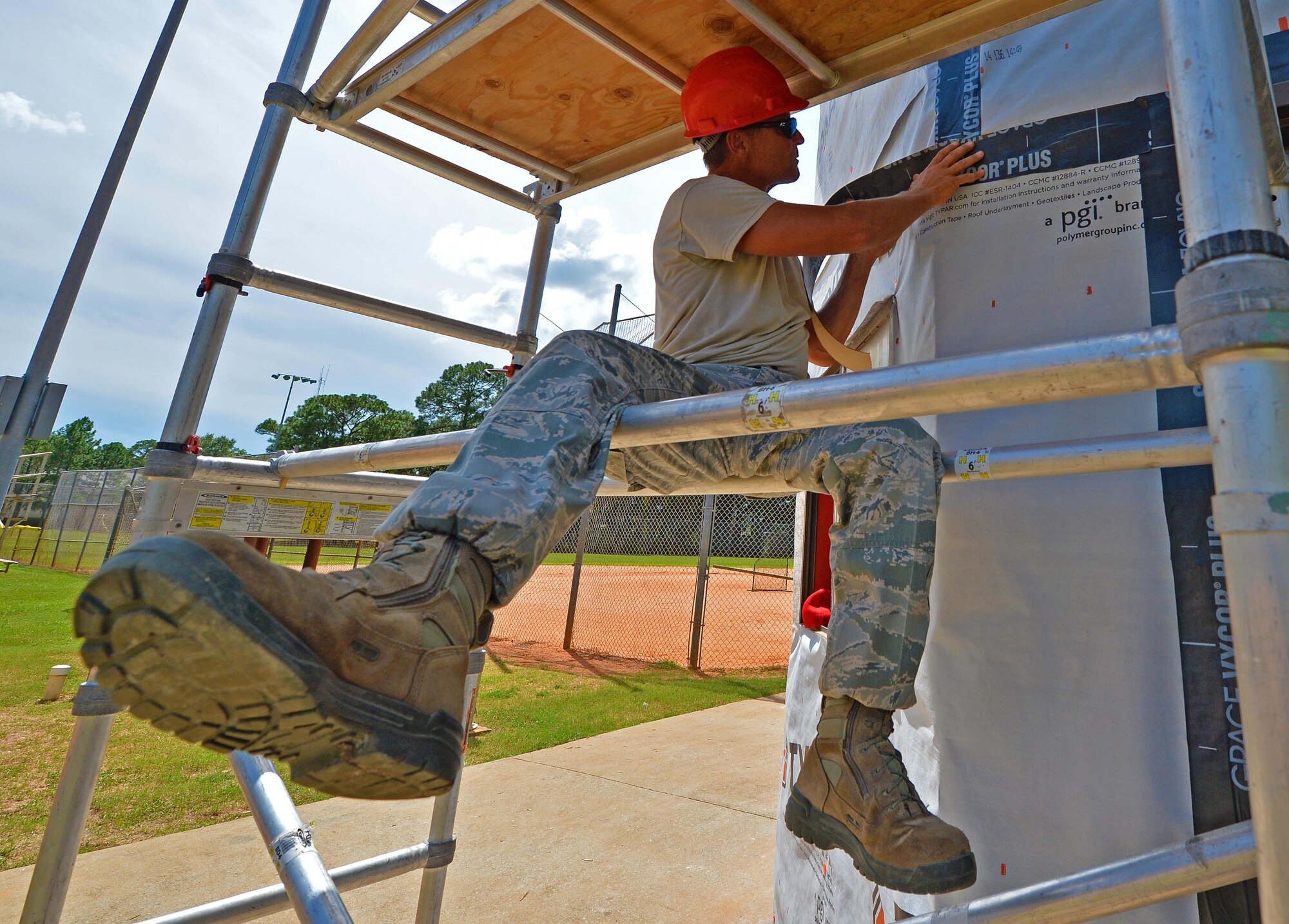 Master Sgt. David Feerick, a structural superintendent with the 556th RED HORSE, presses a roofing underlayment on the wall of the softball field press box at Hurlburt Field Fla., Sept. 13, 2016. This underlayment seals cracks and openings to prevent moisture and other hazards from entering a building. (U.S. Air Force photo by Senior Airman Andrea Posey)