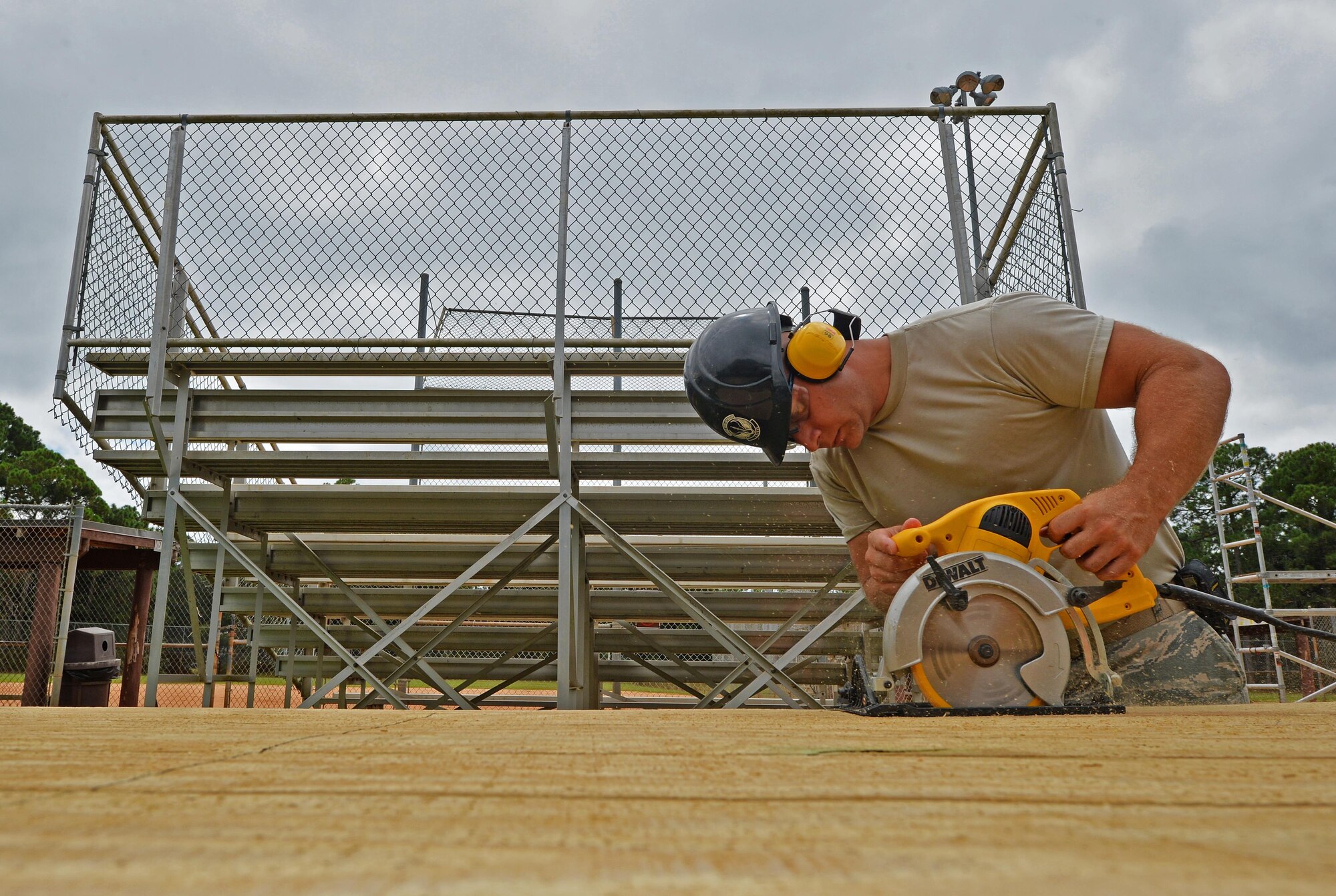 Tech. Sgt. Rickey Schaefer, a structural journeyman with the 556th RED HORSE, cuts planks of wood with a buzz saw during the renovation of the softball field press box at Hurlburt Field Fla., Sept. 14, 2016. These planks are used as exterior walls for the softball field press box. (U.S. Air Force photo by Senior Airman Andrea Posey)