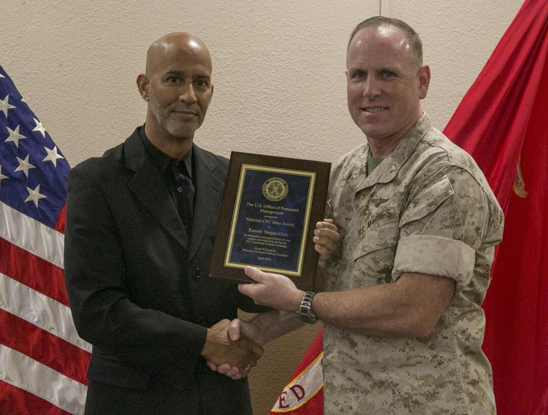 Col. James Harp, Combat Center Chief of Staff, presents the Combined Federal Campaign Hero Award to Ramon Victor-Ortiz, adjutant, G-1 Manpower, during the Combined Federal Campaign Kick-off luncheon at the Frontline Restaurant, Sept. 9, 2016. (Official Marine Corps photo by Lance Cpl. Dave Flores/Released)
