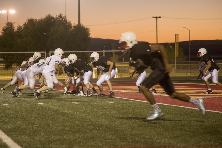 Marines and sailors from the 1st Tank Battalion football team and the Robert E. Bush Naval Hospital Twentynine Palms and Marine Corps Communication-Electronics School’s joint team prepare to run a play during the Marine Corps Community Services Sports hosted Football Jamboree at Felix Field, Sept. 14, 2016. The event is held annually and functions as a pre-season game for the Intramural Tackle Football League. (Official Marine Corps photo by Cpl. Medina Ayala-Lo/Released)
