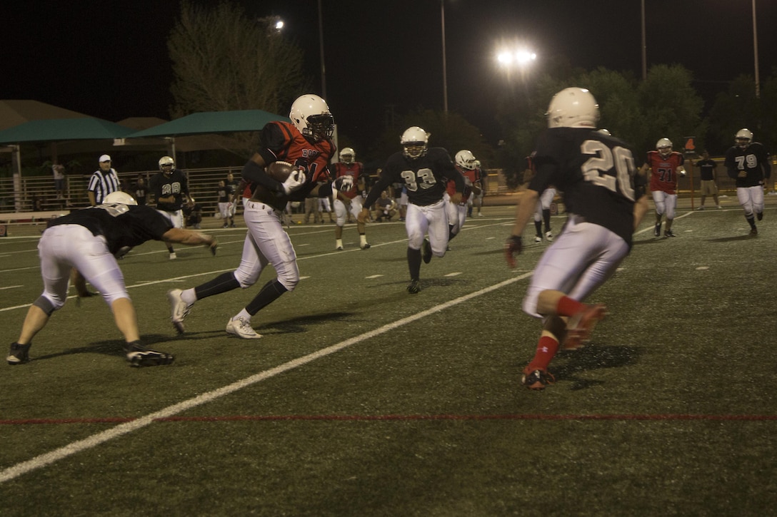 A Marine with the Headquarters Battalion football team evades players from the Robert E. Bush Naval Hospital Twentynine Palms and Marine Corps Communication-Electronics School’s joint team during the Marine Corps Community Services Sports hosted Football Jamboree at Felix Field, Sept. 14, 2016. The event is held annually and functions as a pre-season game for the Intramural Tackle Football League. (Official Marine Corps photo by Cpl. Medina Ayala-Lo/Released)