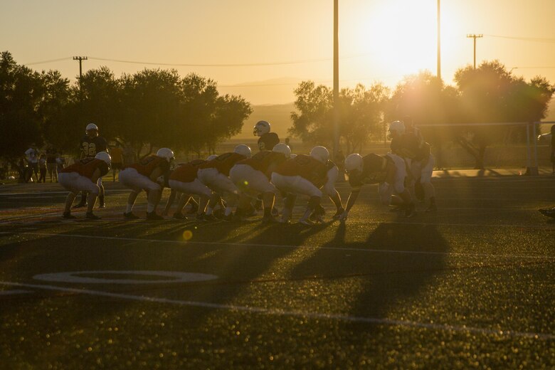 Marines and sailors from the Headquarters Battalion football team and the Robert E. Bush Naval Hospital Twentynine Palms and Marine Corps Communication-Electronics School’s joint team prepare to hike the ball during the Marine Corps Community Services Sports hosted Football Jamboree at Felix Field, Sept. 14, 2016. The event is held annually and functions as a pre-season game for the Intramural Tackle Football League. (Official Marine Corps photo by Cpl. Medina Ayala-Lo/Released)