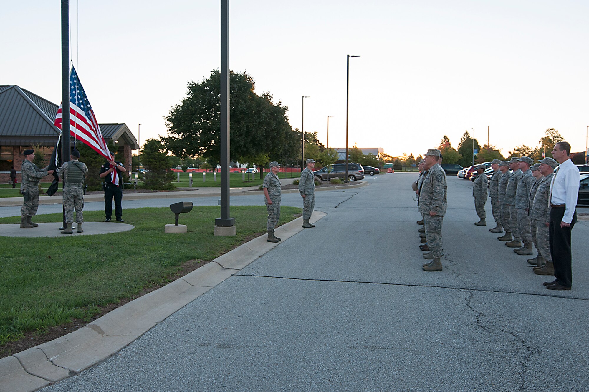 Airmen and civilian employees stand at attention as the POW/MIA flag is raised with the American Flag during a ceremony at Grissom Air Reserve Base, Ind. Sept. 12, 2016. The National League of Families’ POW/MIA flag symbolizes the United States’ resolve to never forget prisoners of war or those who served their country in conflicts and are still missing. (U.S. Air Force photo/Staff Sgt. Dakota Bergl) 