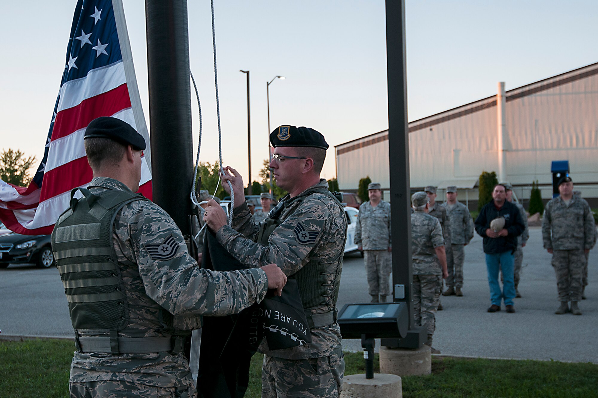 Grissom Airmen and civilian employees stand at attention as two 434th Security Forces Squadron members prepare to raise the POW/MIA flag during a ceremony at Grissom Air Reserve Base, Ind. Sept. 12, 2016. The Grissom employees gathered to pay respects to the many U.S. service members who were captured or went wising in the line of duty. (U.S. Air Force photo/Staff Sgt. Dakota Bergl) 