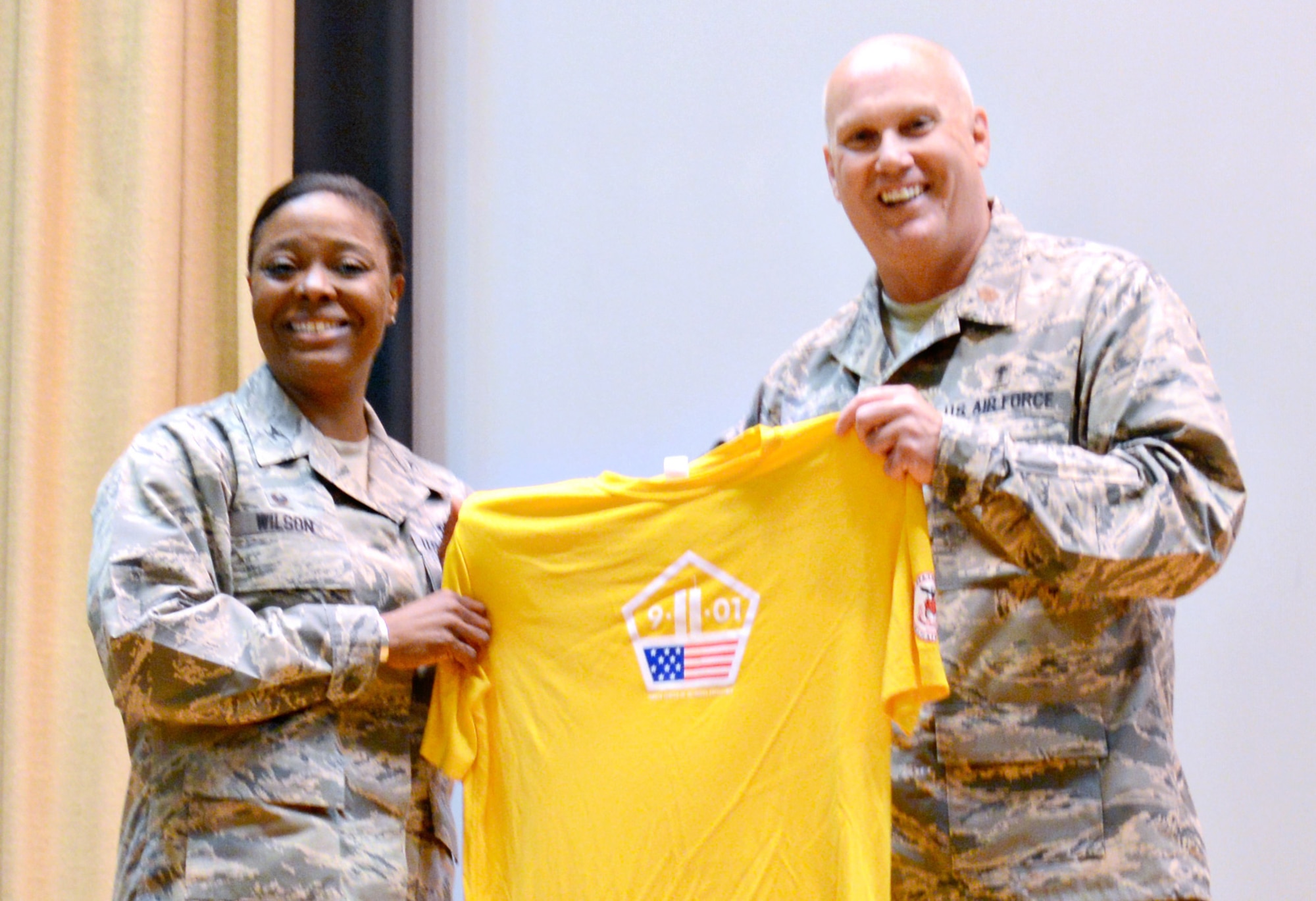 Chaplain (Maj.) Paul Joyner presented 72nd Air Base Wing Commander Col. Stephanie Wilson with a personalized shirt for the 9-11 Memorial Run during the 9-11 Resiliency Luncheon Sept. 8. The luncheon also featured Staff Sgt. Larry Coffie, with the 552nd Aircraft Maintenance Squadron, reading his winning Freedom Citation essay, as well as Chaplain Joyner speaking about the significance of the theme of this year’s 9-11 memorial events, United, Remember, Defend. (Air Force photo by Kelly White)