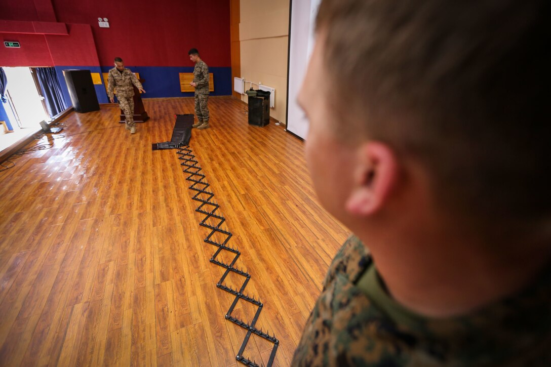 U.S. Marine Cpl. Philip Miller, a military police Marine with 3rd Law Enforcement Battalion, III Marine Expeditionary Force, deploys a spike-strip system during Non-Lethal Weapons Executive Seminar (NOLES) 2016 at the Five Hills Training Area, Mongolia, Sept. 14, 2016. The Marines showed the Mongolian Armed Forces and Mongolian National Police Department how to properly set up a spike-strip system to disable vehicles during different law enforcement operations. NOLES is a regularly scheduled field training exercise and leadership seminar hosted annually by various nations throughout Asia-Pacific. 