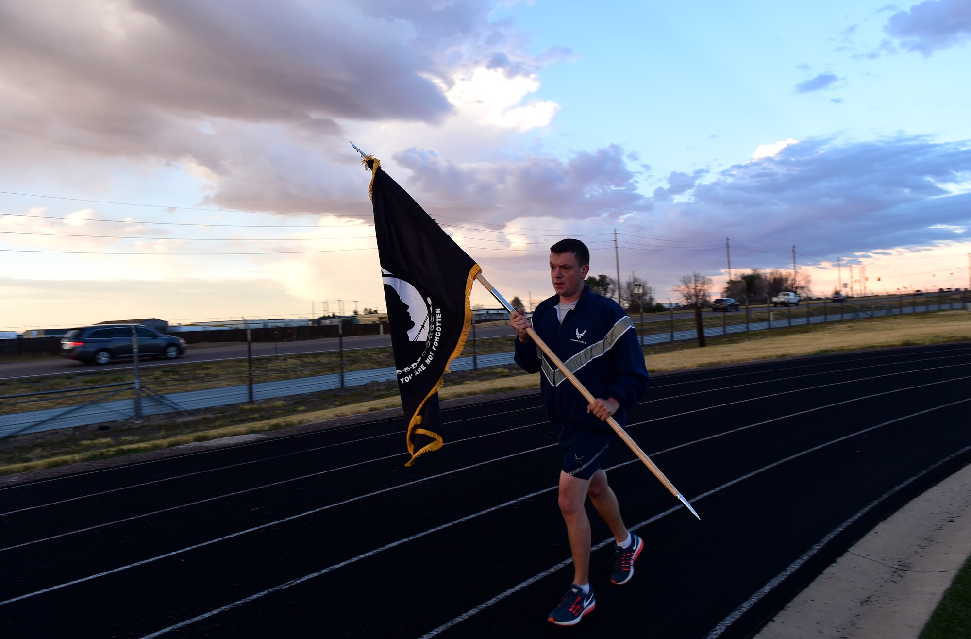 A participant in a 24-hour POW/MIA memorial run  carries a flag Sept. 15, 2016, at an outdoor track on Buckley Air Force Base, Colo. Team Buckley members ran in two-hour shifts to remember those service members who sacrificed their lives. (U.S. Air Force photo by Airman 1st Class Gabrielle Spradling/Released)