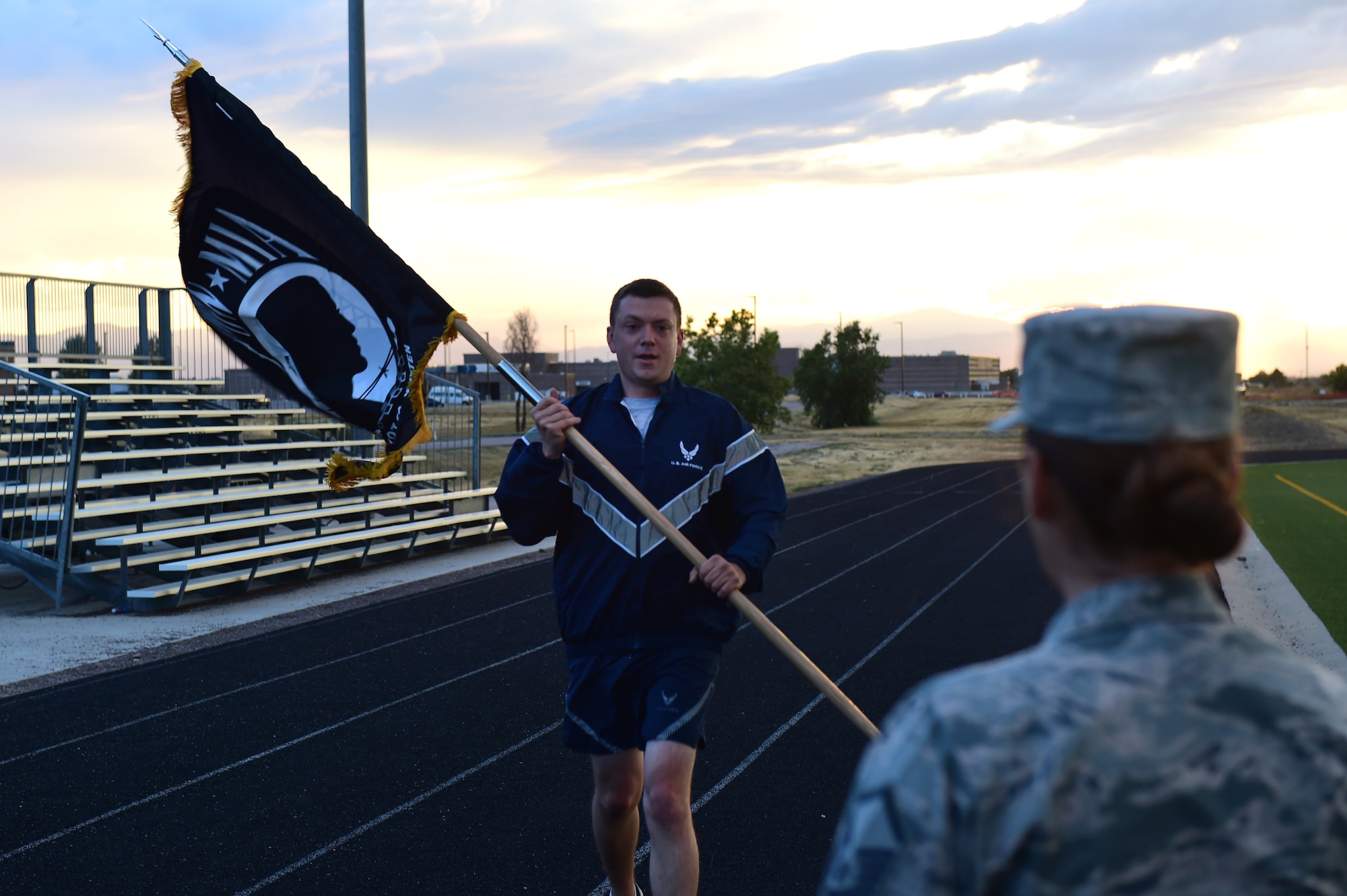 Team Buckley members prepare to pass the POW/MIA flag during a 24-hour memorial run Sept. 15, 2016, at an outdoor track on Buckley Air Force Base, Colo. The flag reminds all who see it the service members imprisoned or missing in action are not forgotten.. (U.S. Air Force photo by Airman 1st Class Gabrielle Spradling/Released)